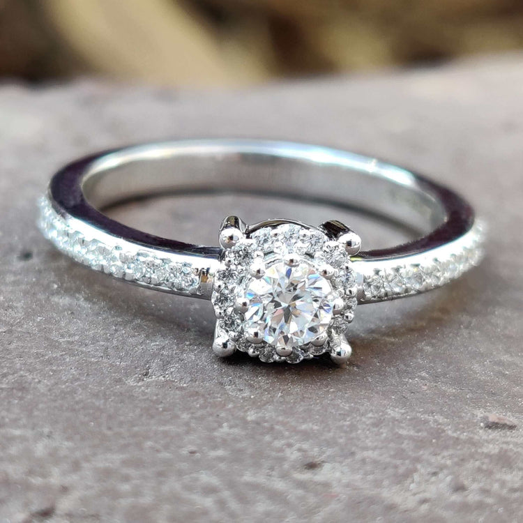 Round cut moissanite halo ring in white gold.