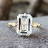 Emerald cut moissanite engagement ring in yellow gold.