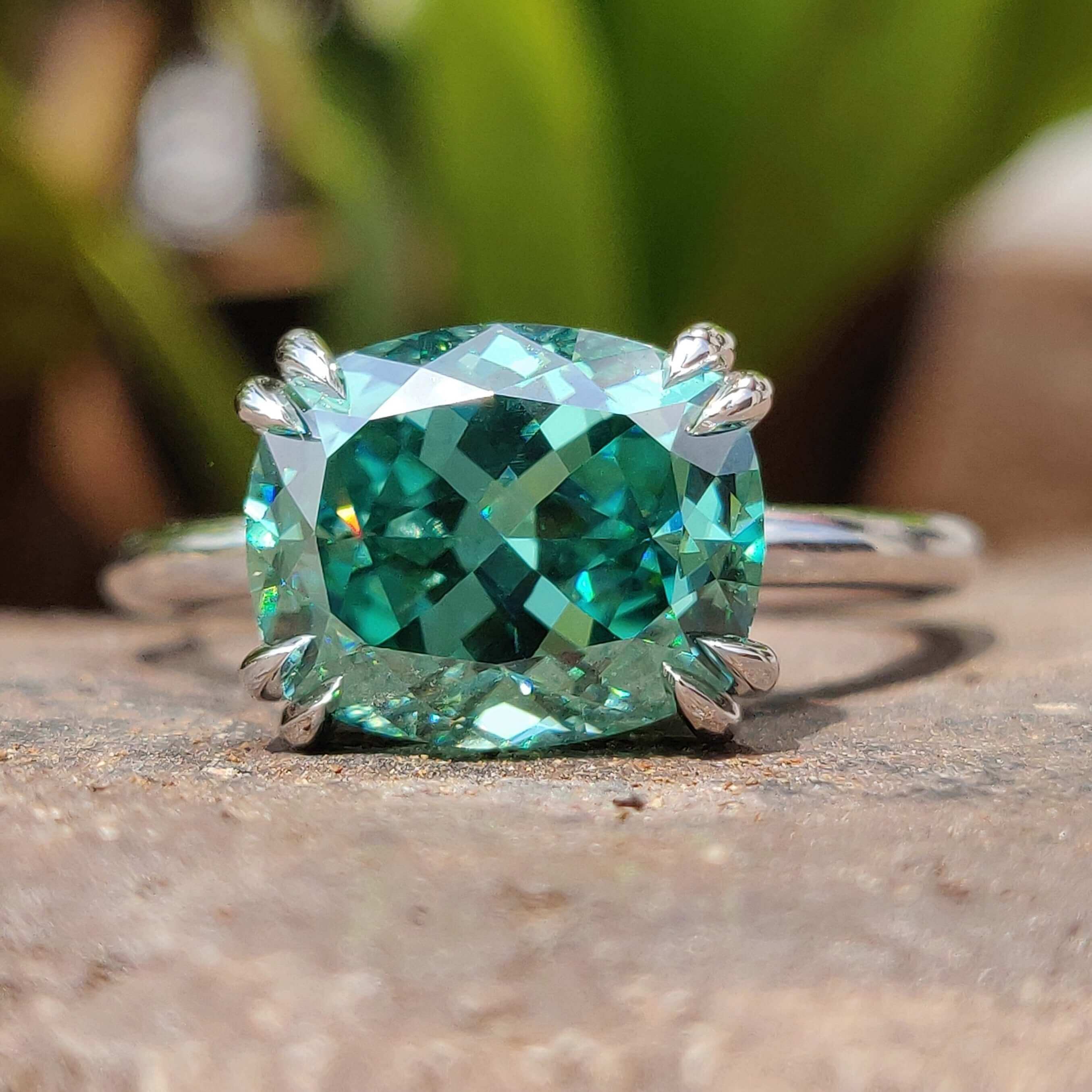 Green cushion cut moissanite ring in white gold.