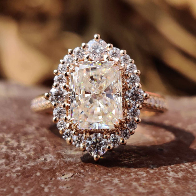 Radiant cut moissanite ring with round halo in rose gold.