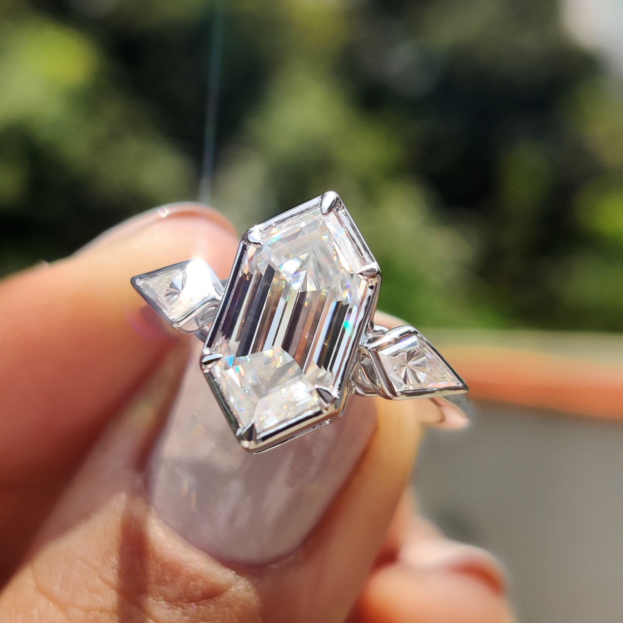 Hexagon ring with bezel setting and two kite cut side stones.