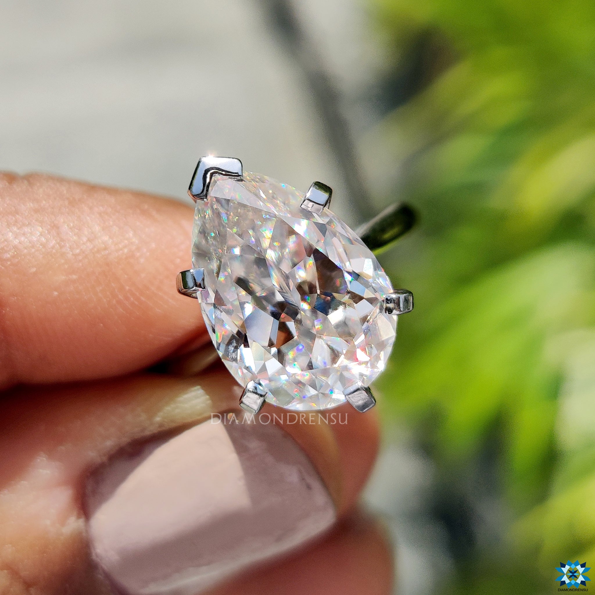 White gold solitaire engagement ring with handcrafted 5.17 carat pear moissanite.