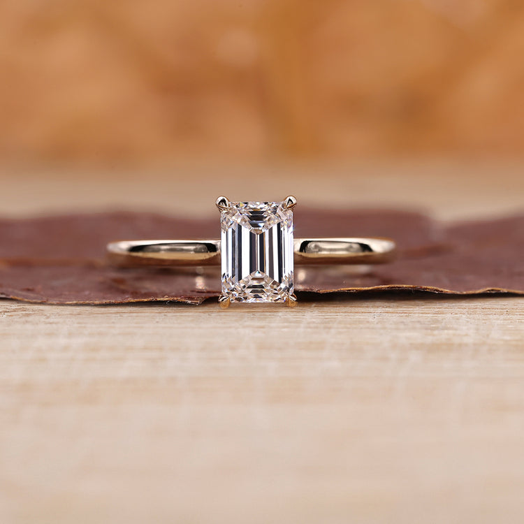 Emerald cut diamond ring with yellow gold band.