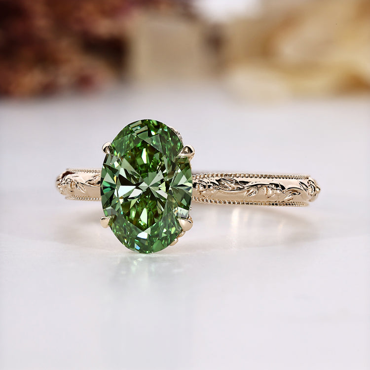 Oval cut engagement ring with green diamond solitaire.