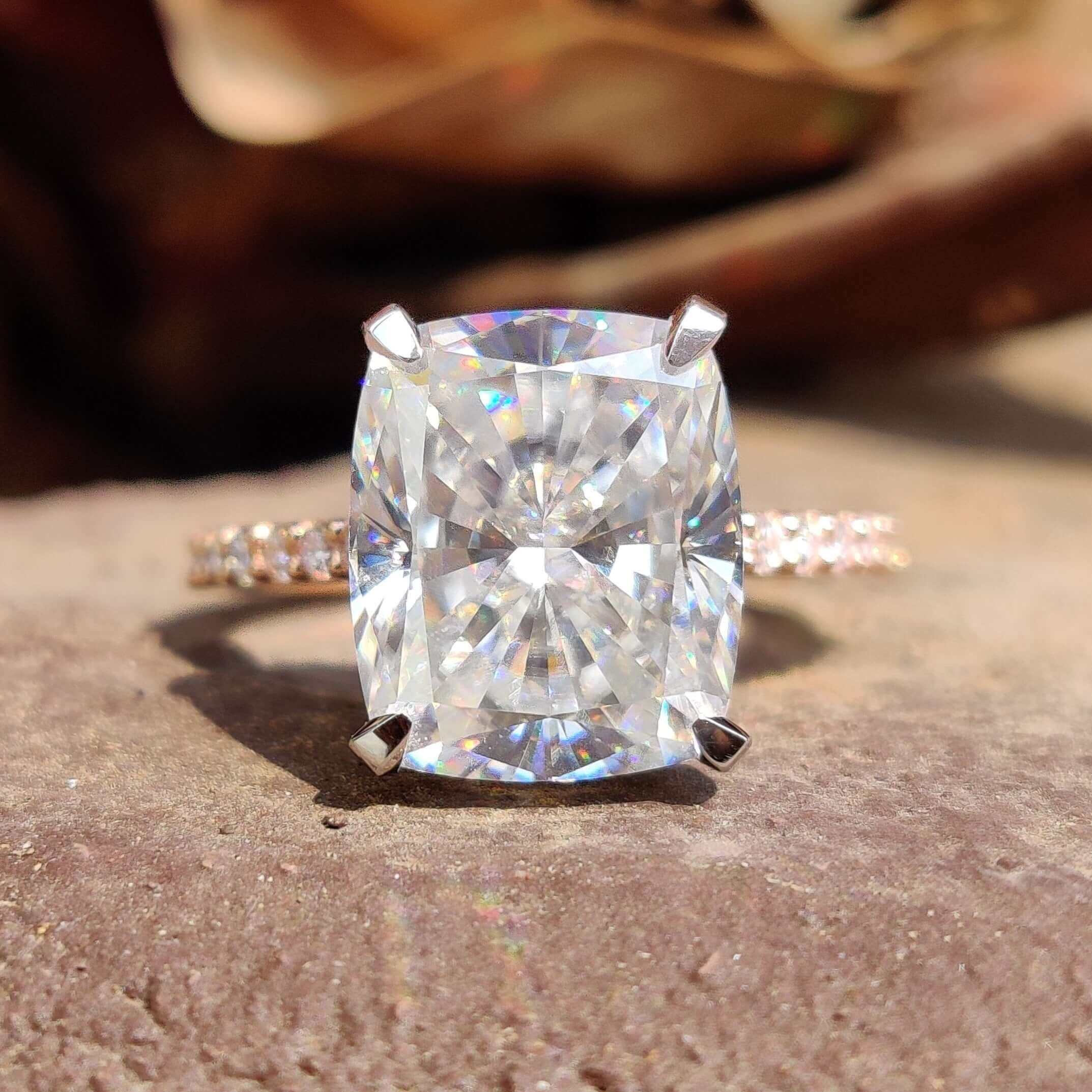Elongated cushion cut moissanite ring with pave band.