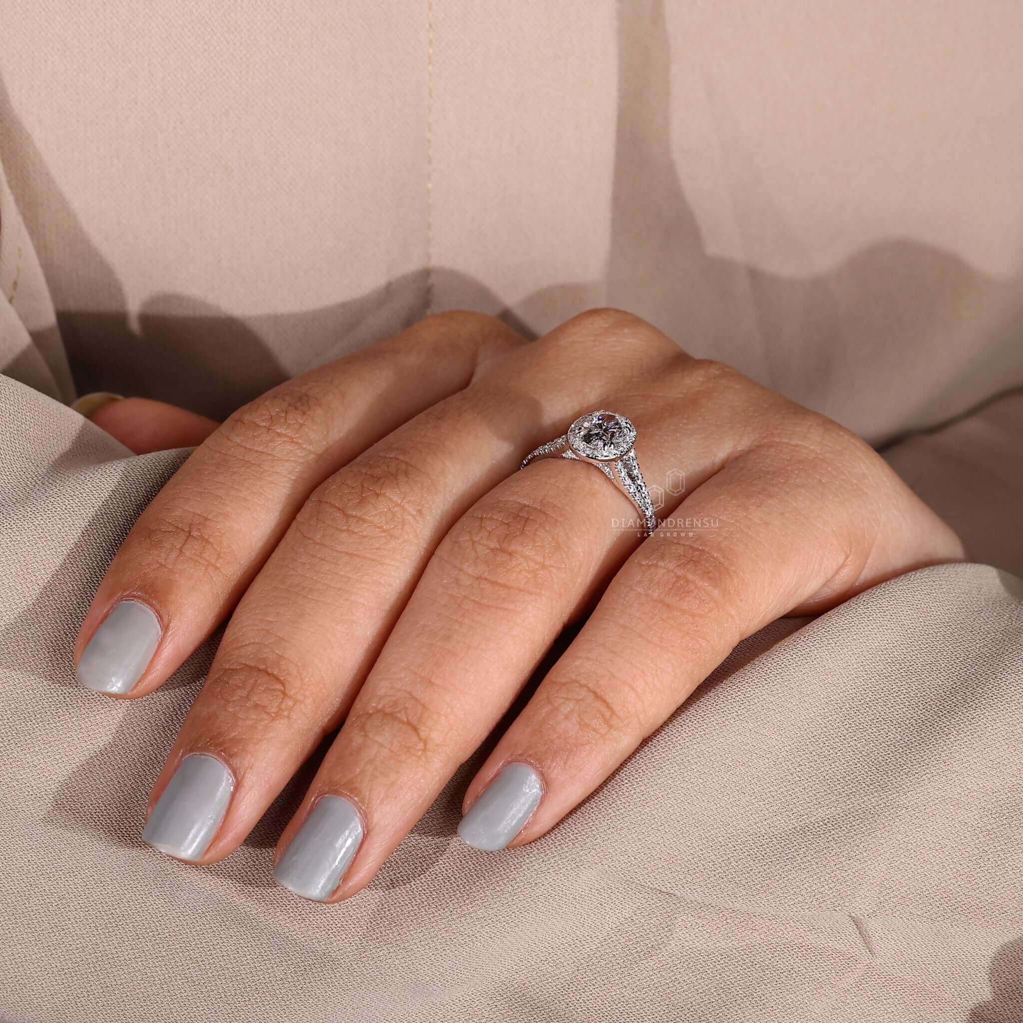 Oval side stone engagement ring in white gold with halo accents.
