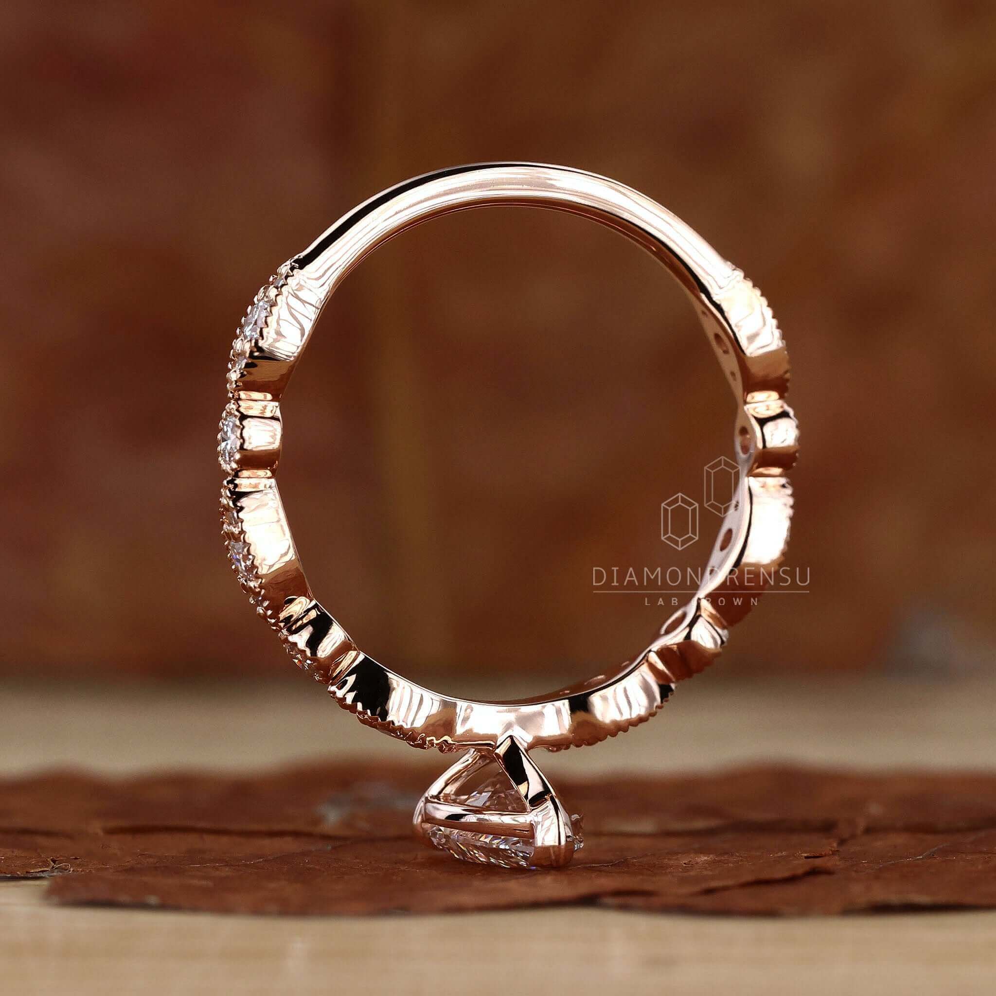Claw prong engagement ring showcasing a pear shaped engagement ring in a rose gold setting.