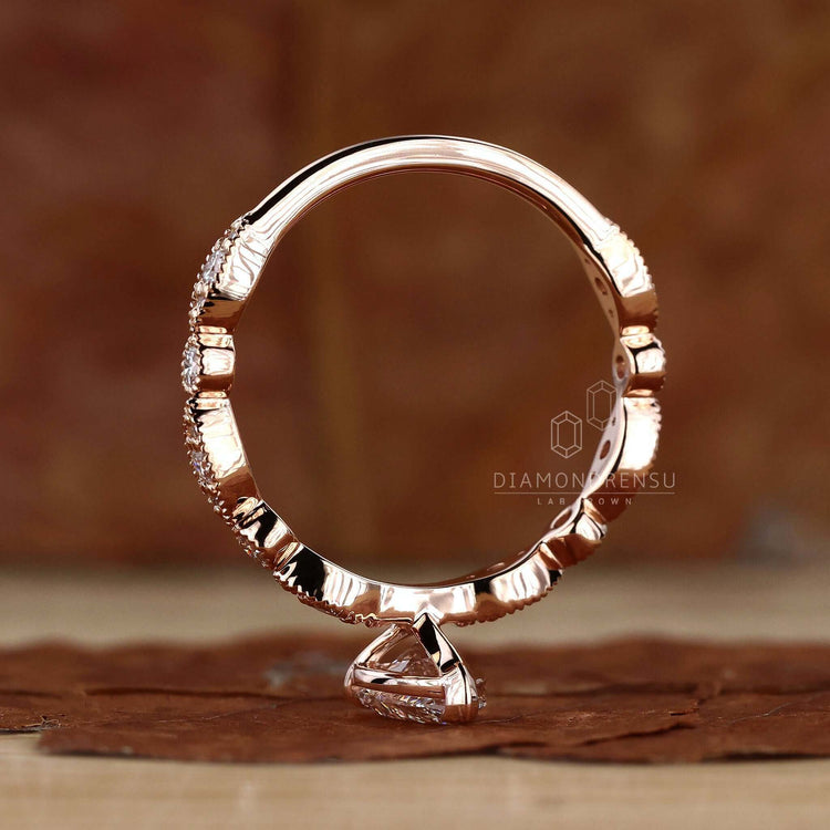 Claw prong engagement ring showcasing a pear shaped engagement ring in a rose gold setting.