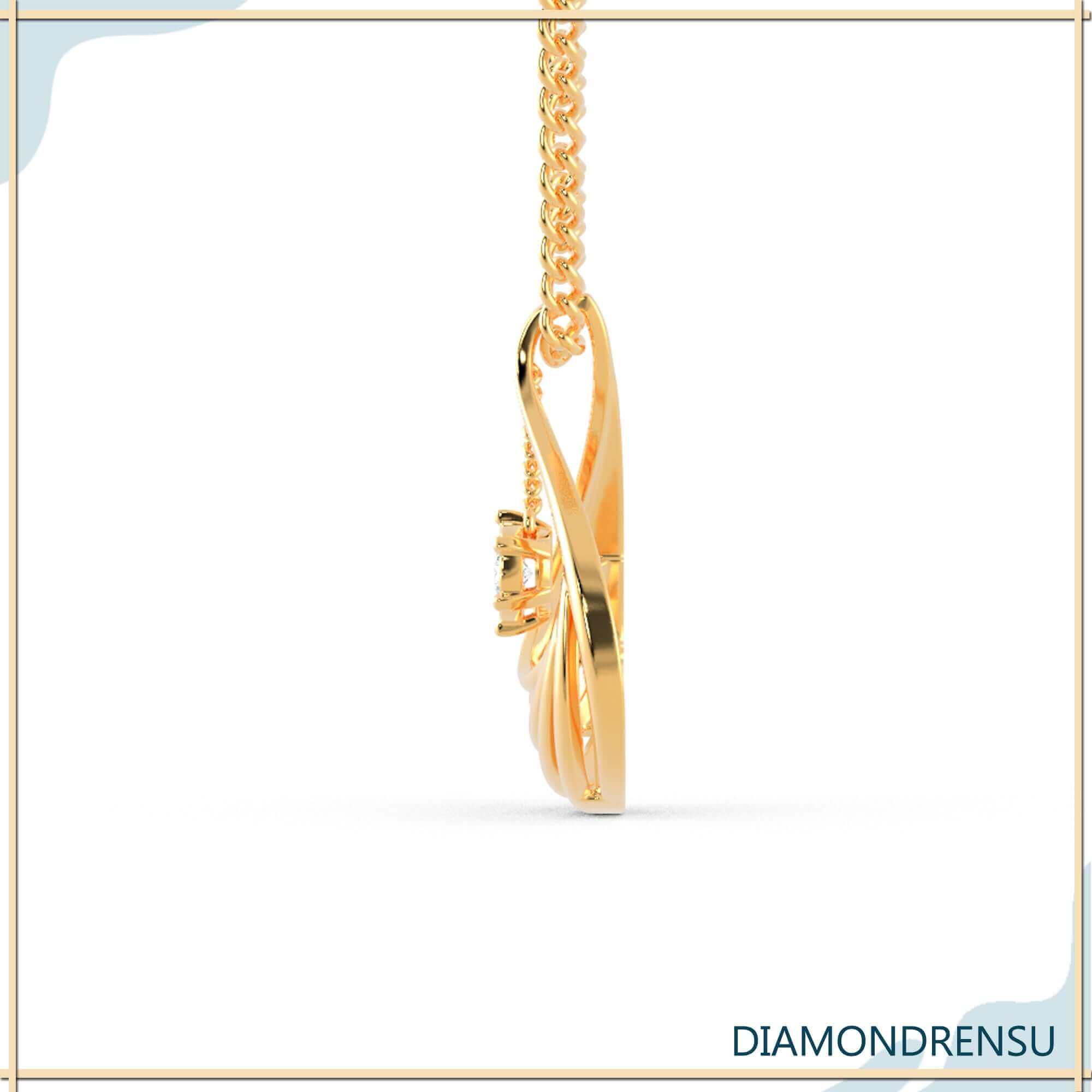 Gold pendant with round brilliant diamond and sunburst teardrop design.