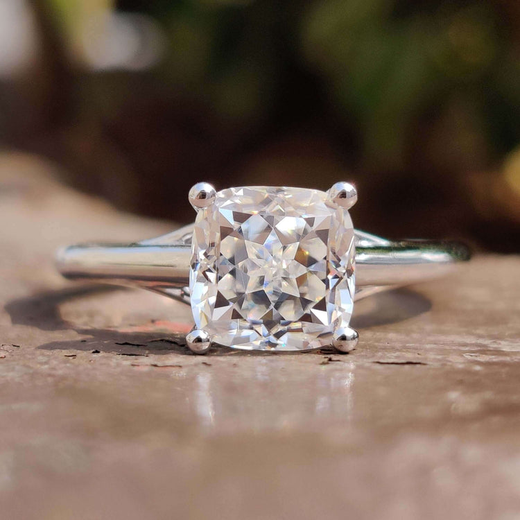 Cushion Rensu cut solitaire engagement ring with four prong setting in white gold.