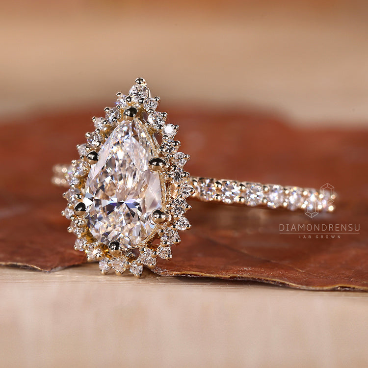6 prong ring setting featuring a pear cut diamond and yellow gold band.