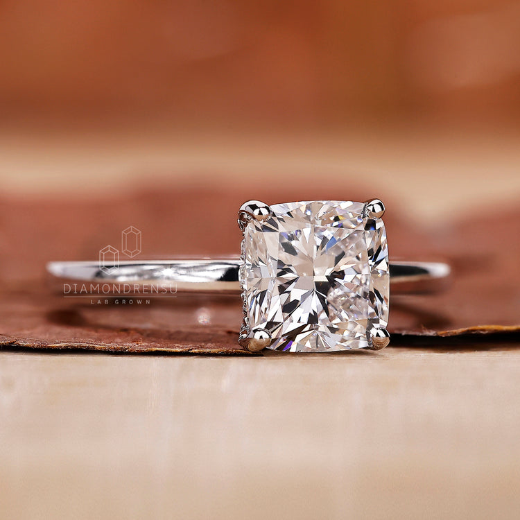 Cushion cut diamond ring with 4 prong ring setting and hidden halo.