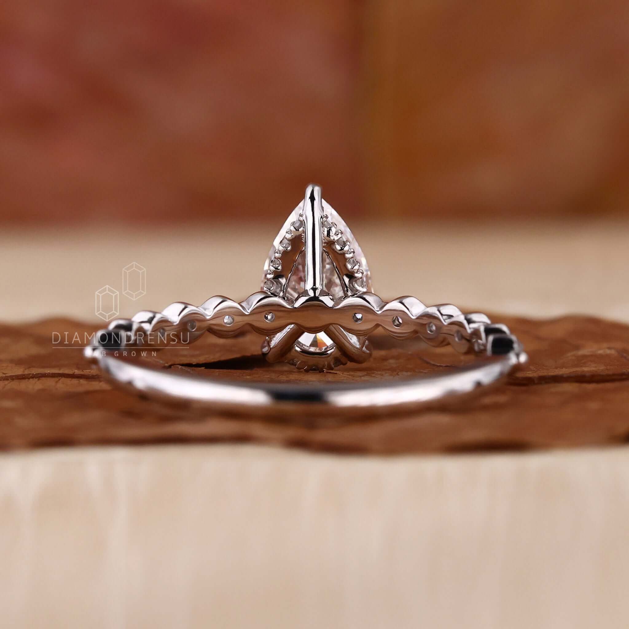 Pear diamond engagement ring with a stunning pave diamond ring design for added brilliance.