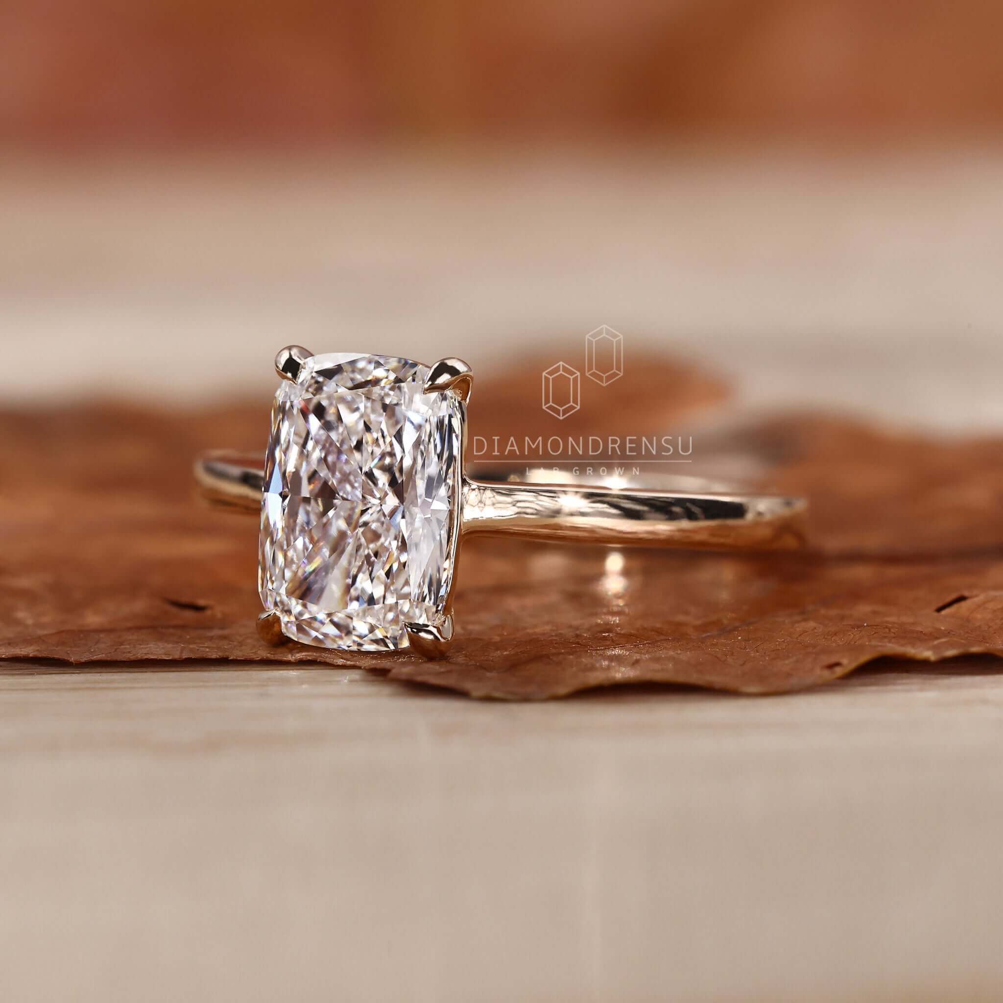 Gold solitaire engagement ring crafted with an elongated cushion diamond.