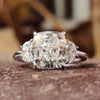 Cushion cut moissanite ring with half moon side stones.