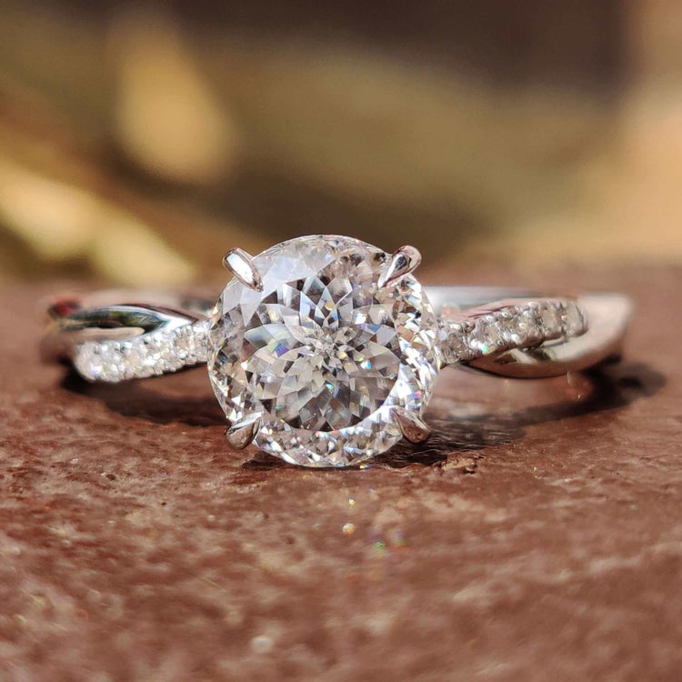 Portuguese cut moissanite engagement ring with twisted band in white gold.