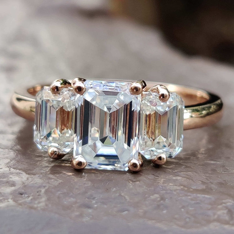 Three stone emerald cut moissanite ring in rose gold.