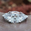 Three stone moissanite ring with cushion cut center and trillion side stones.
