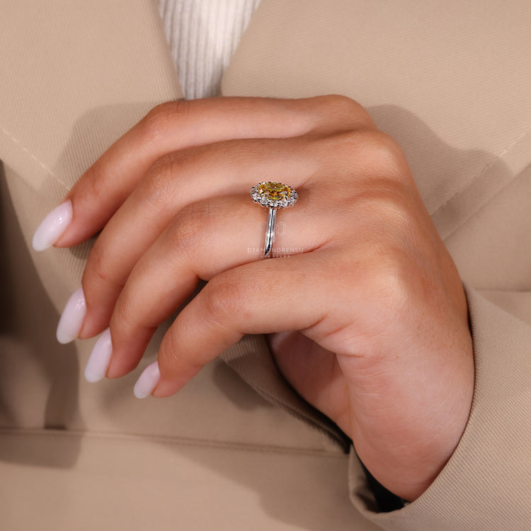 Round diamond halo ring featuring an oval center.