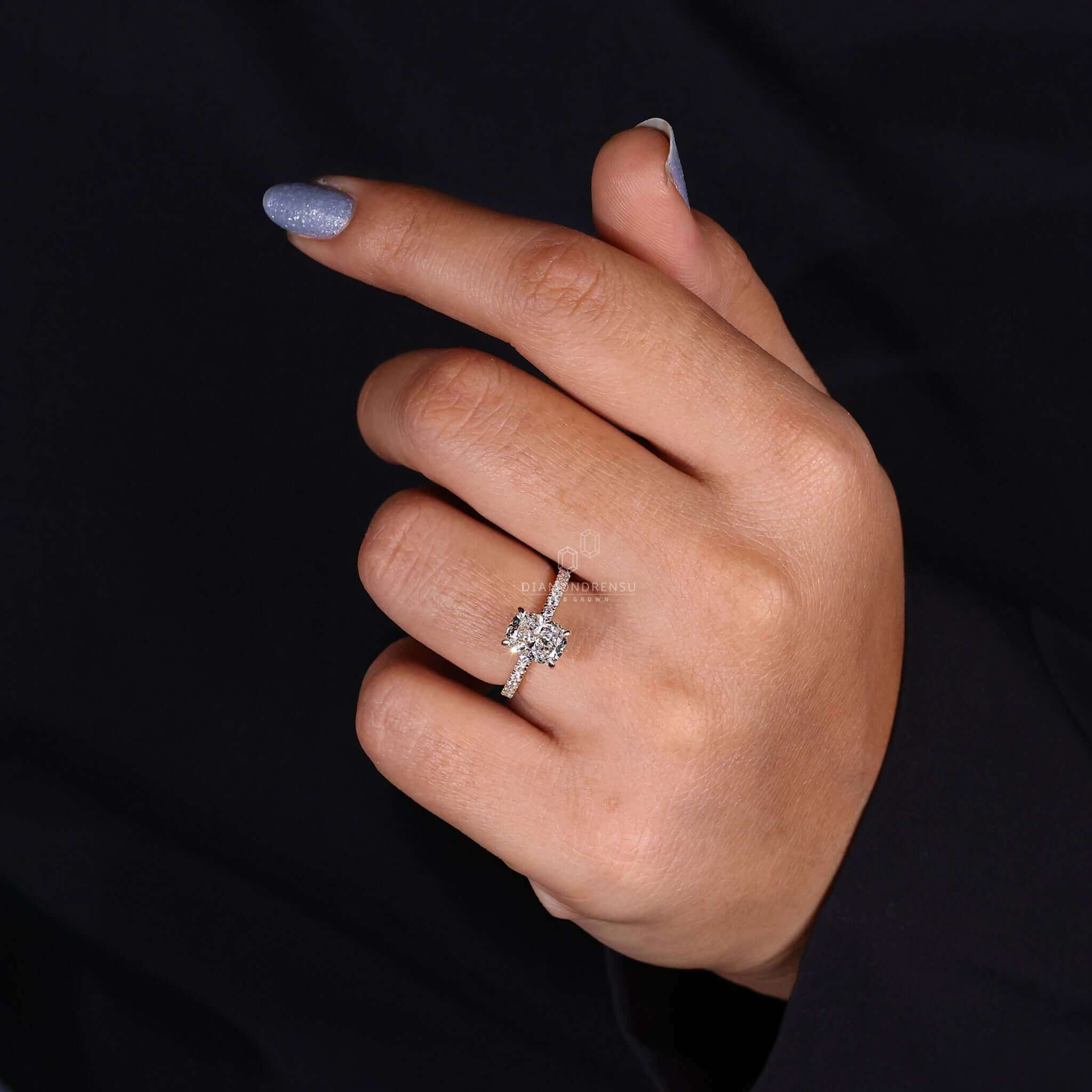 Elongated cushion cut engagement ring with pave band engagement ring details.