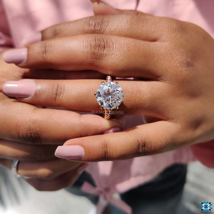 Rose gold ring with round moissanite and secure claw prong setting.