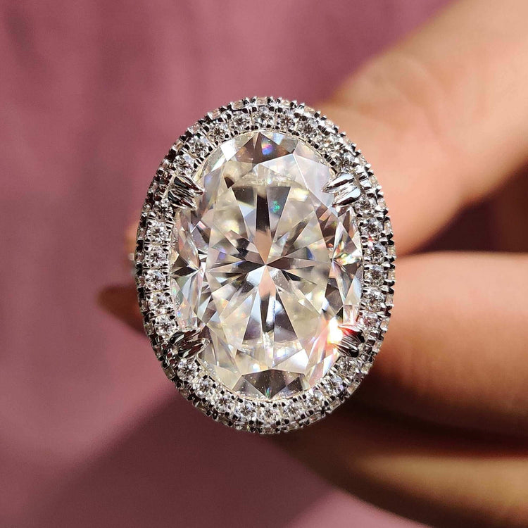 Gold oval moissanite ring with double claw prongs.
