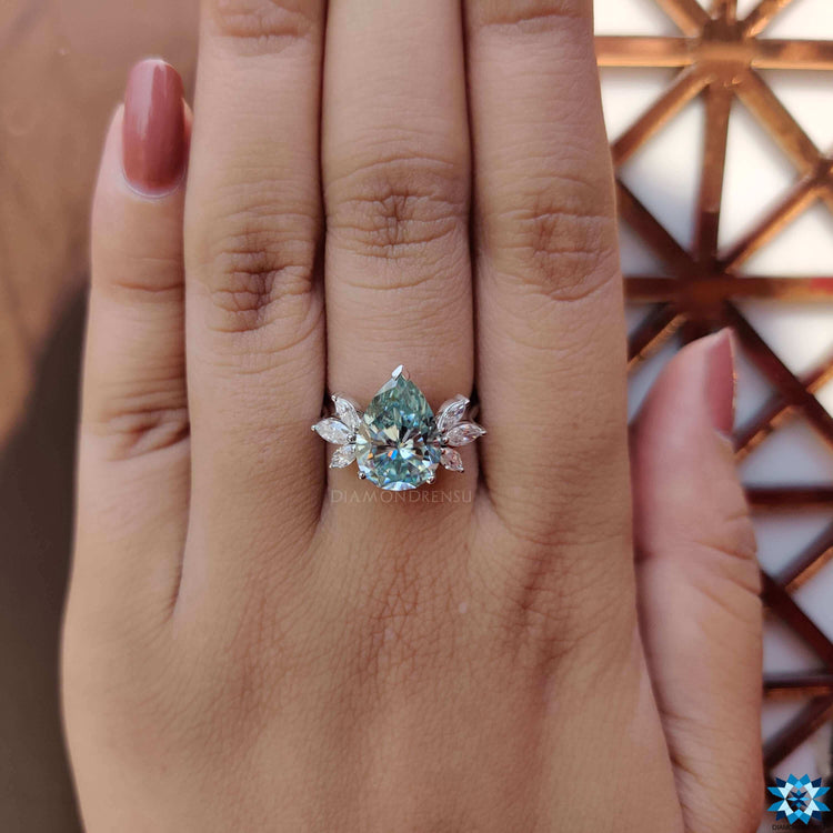 Blue pear cut moissanite ring with v shaped prongs.