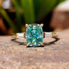 Cyan blue moissanite three stone engagement ring in yellow gold.