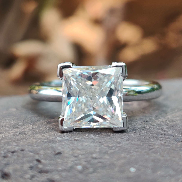 Princess cut moissanite solitaire ring in white gold.