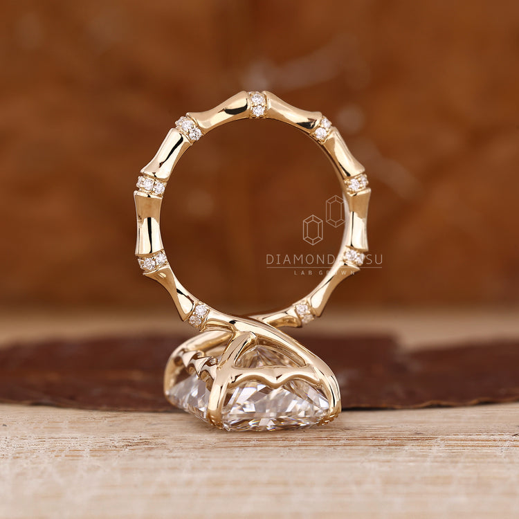 Radiant diamond ring with four leaf style prong.