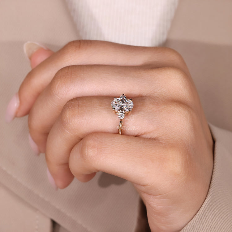 Handmade oval diamond ring with three stone style setting.