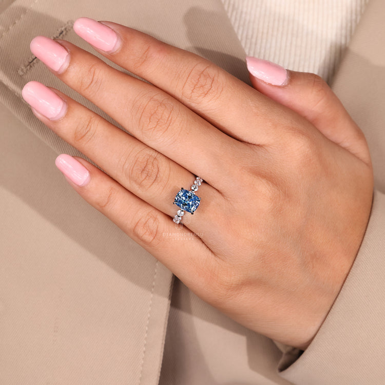 Cushion blue diamond ring with shared pave band design.