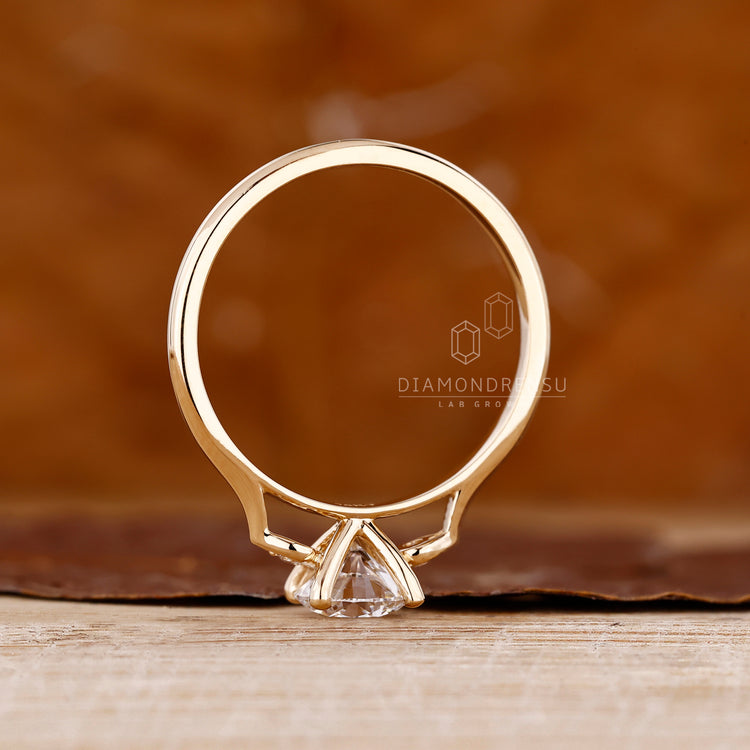 Diamondrensu round ring with side stones and prong setting.