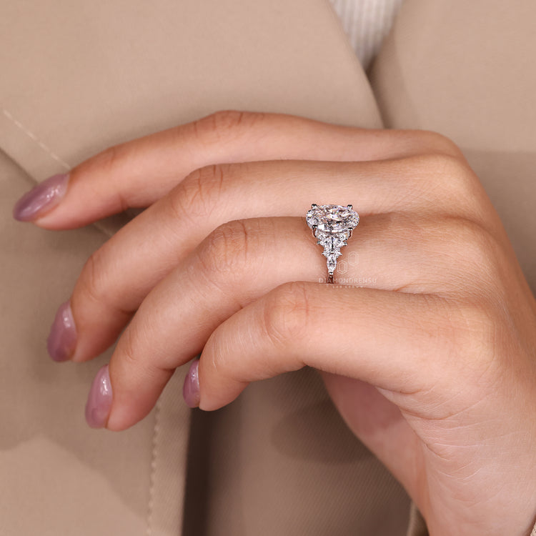 Oval diamond ring with round accents and tapered band.