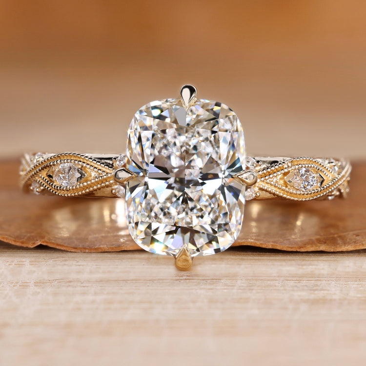 Cushion cut diamond ring with round side stones.