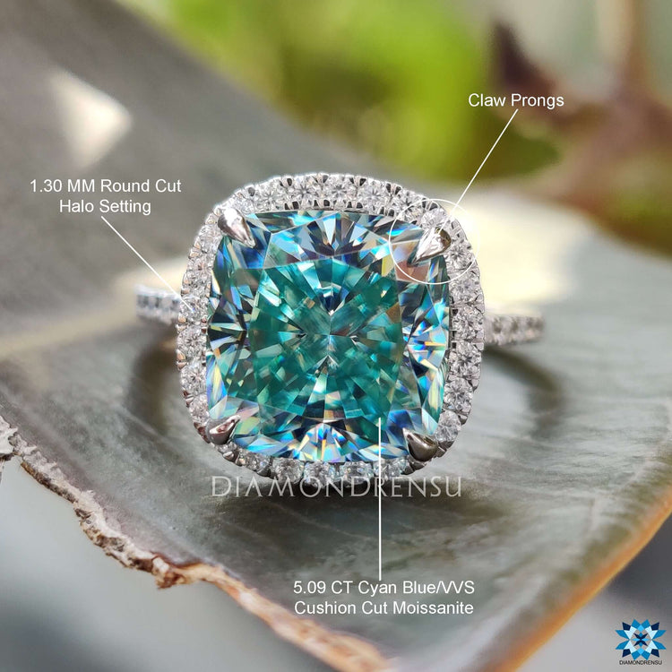 Custom engagement ring made with cushion cut cyan blue moissanite and round cut pave band.