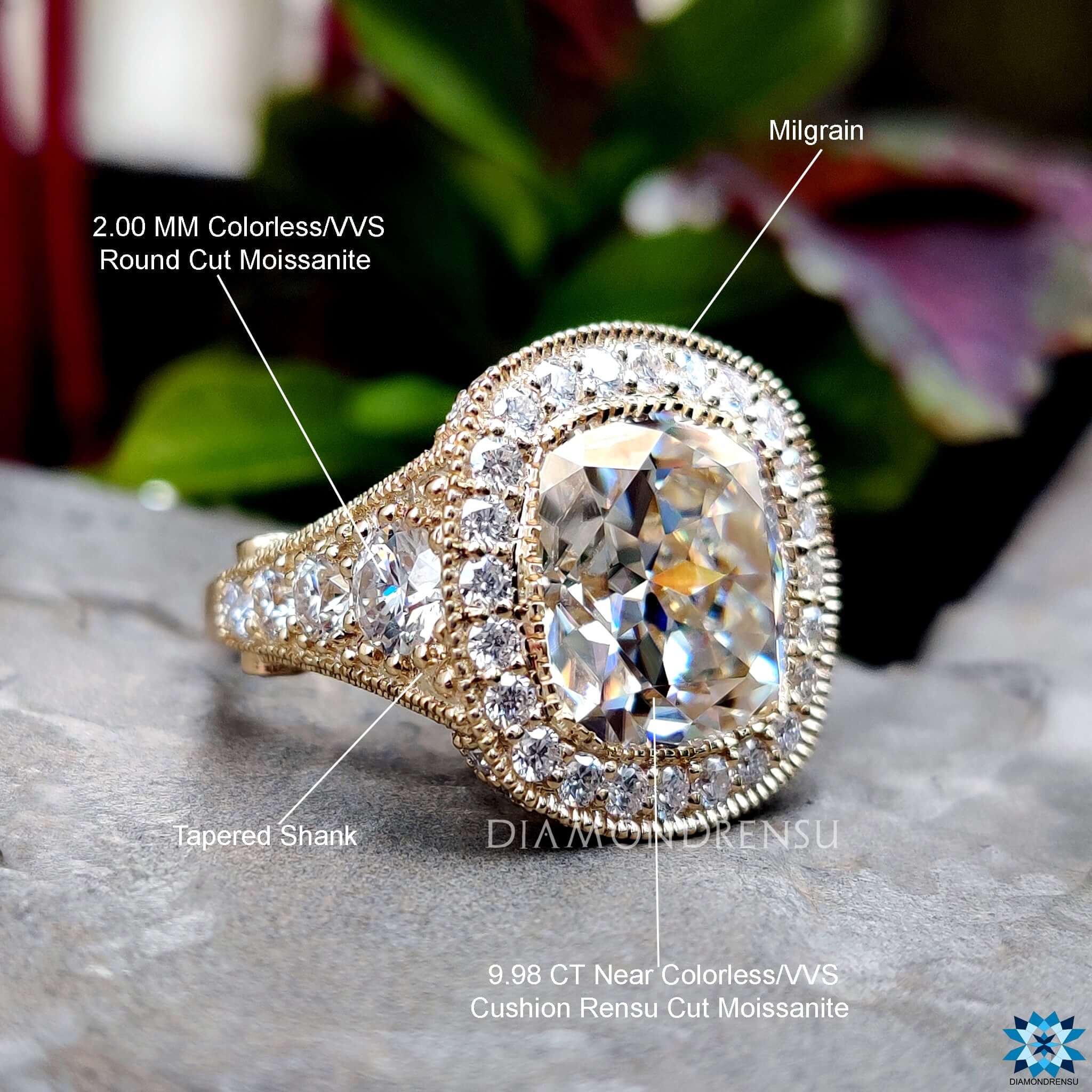 Cushion cut moissanite ring with round accents and milgrain edge.