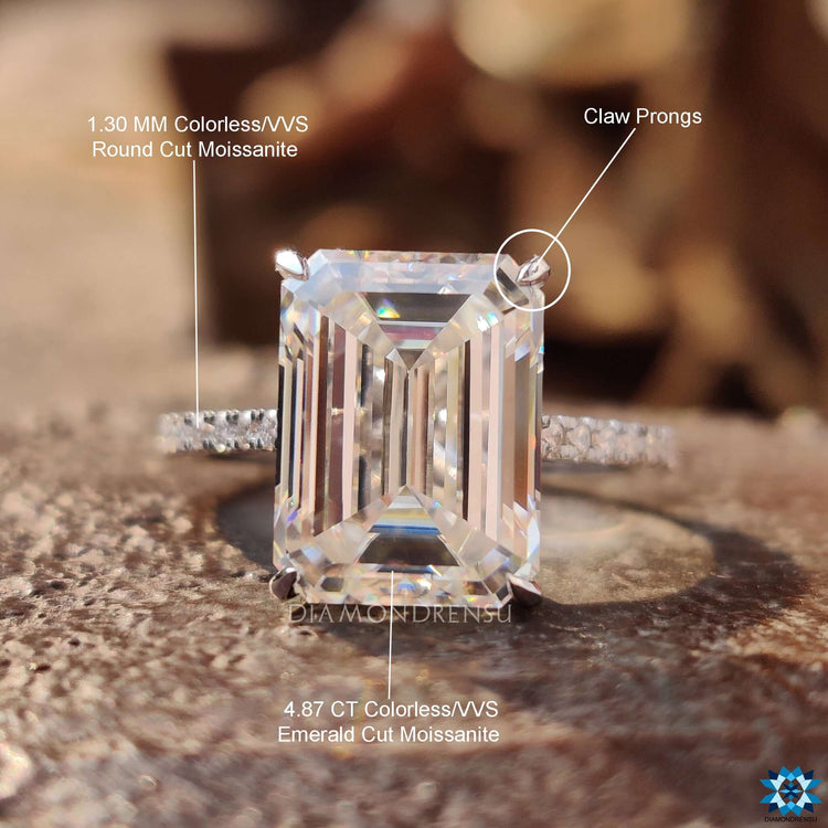 Elegant white gold ring with emerald cut moissanite and claw setting.