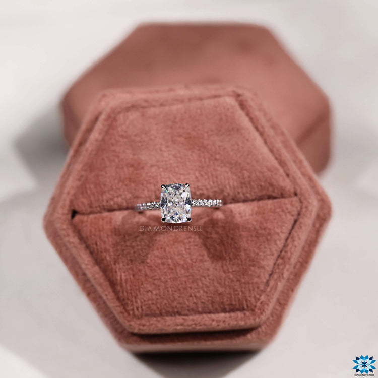 Four claw prong setting holds a cushion moissanite.