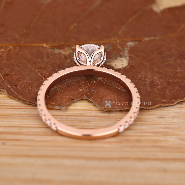 Tulip setting round cut engagement ring with side diamonds.