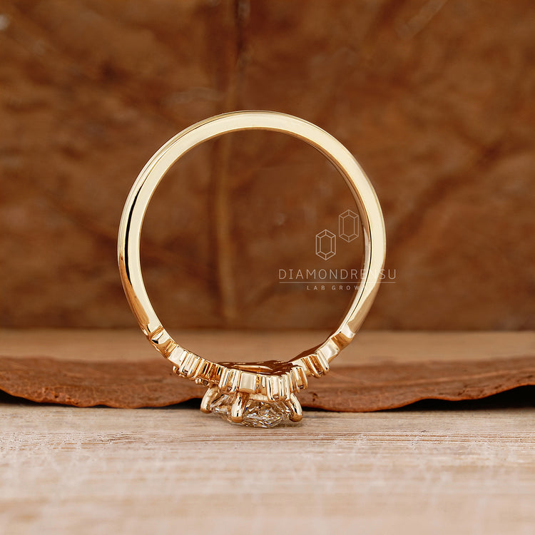 Marquise diamond ring with round side stones and prongs.