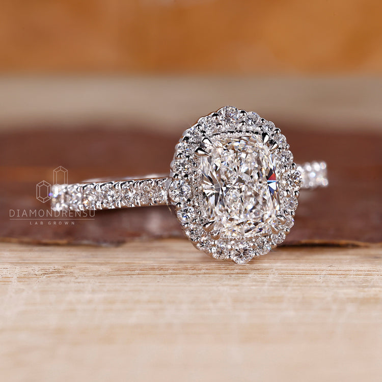 Cushion diamond ring with cathedral setting and pave style.