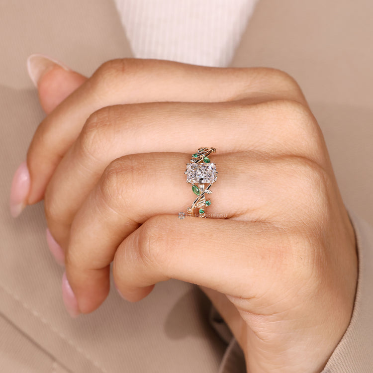 Radiant cut diamond ring with marquise emerald side stones.