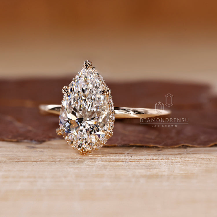 Handmade pear diamond ring with six leaf style prongs.
