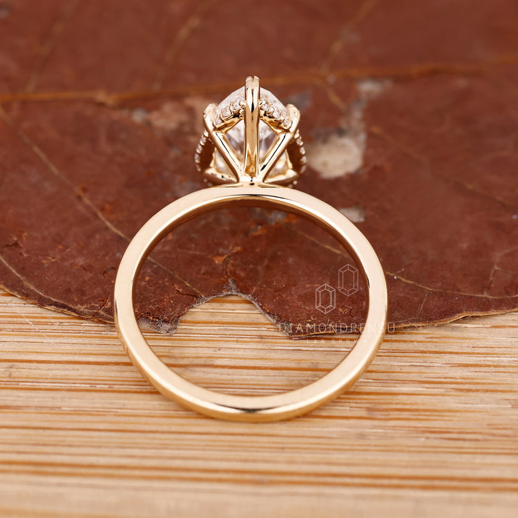 Pear diamond ring with solitaire setting and halo accents.