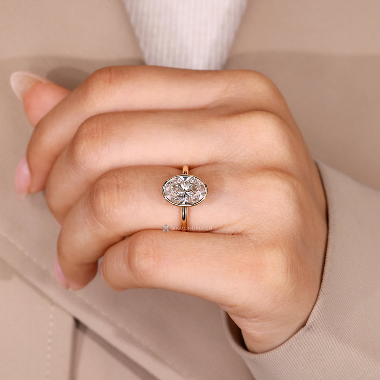 Oval solitaire diamond ring with secure bezel setting.