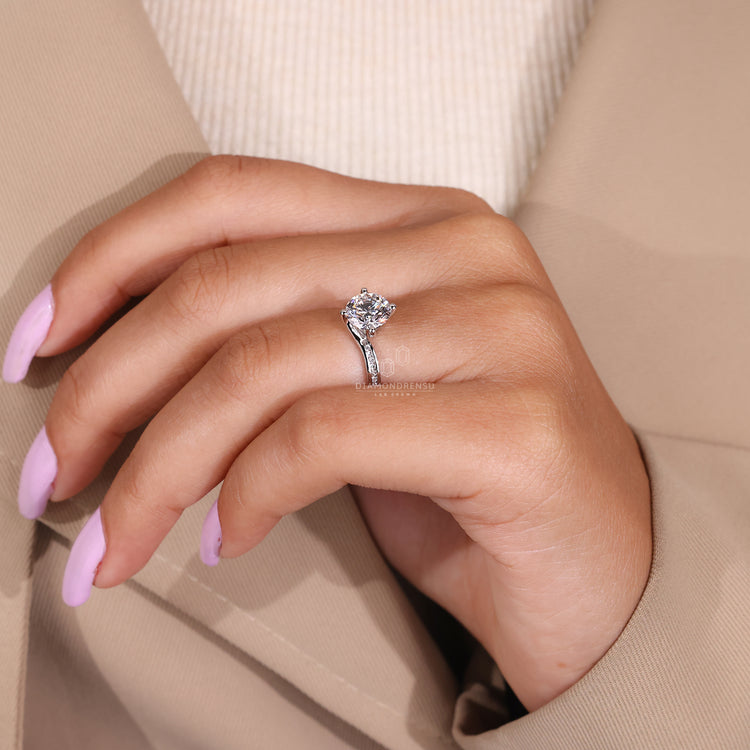 UK engagement ring with round cut diamond center stone.