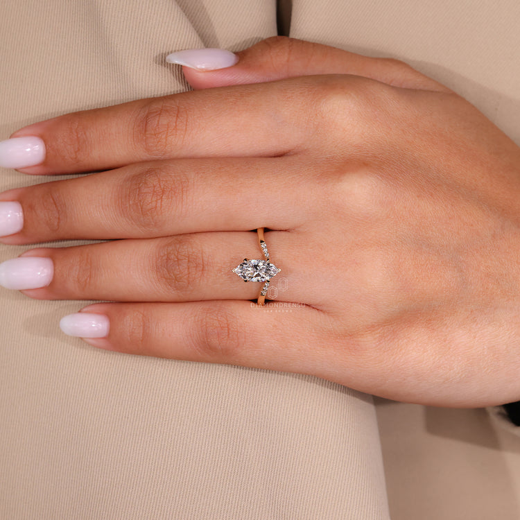 V and Claw Prong Setting holds marquise diamond center stone.