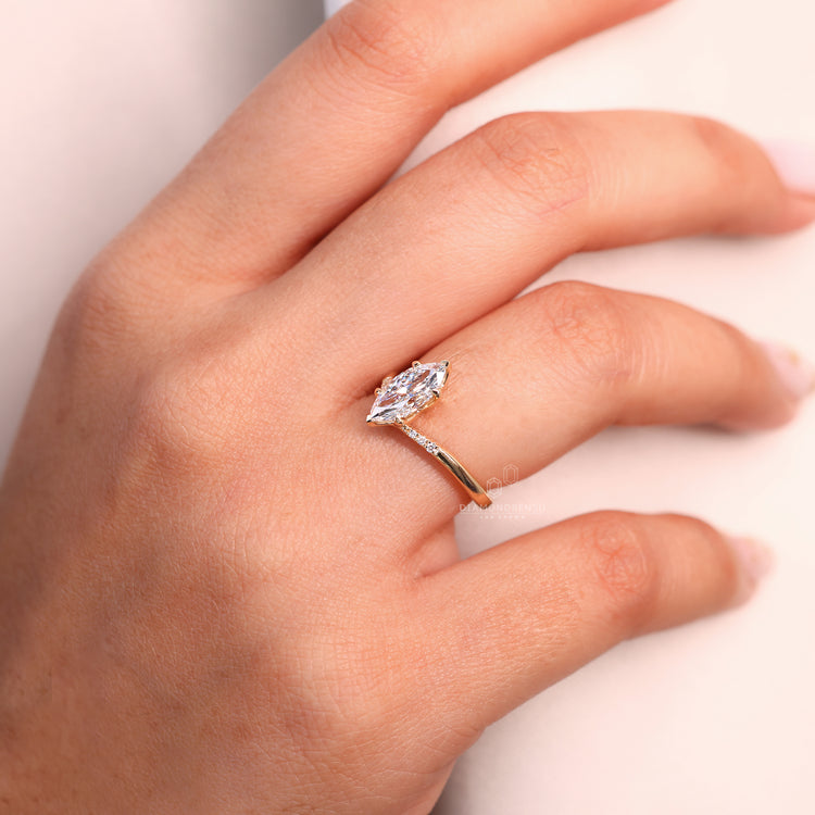 Round diamond side stone added beside marquise center diamond.