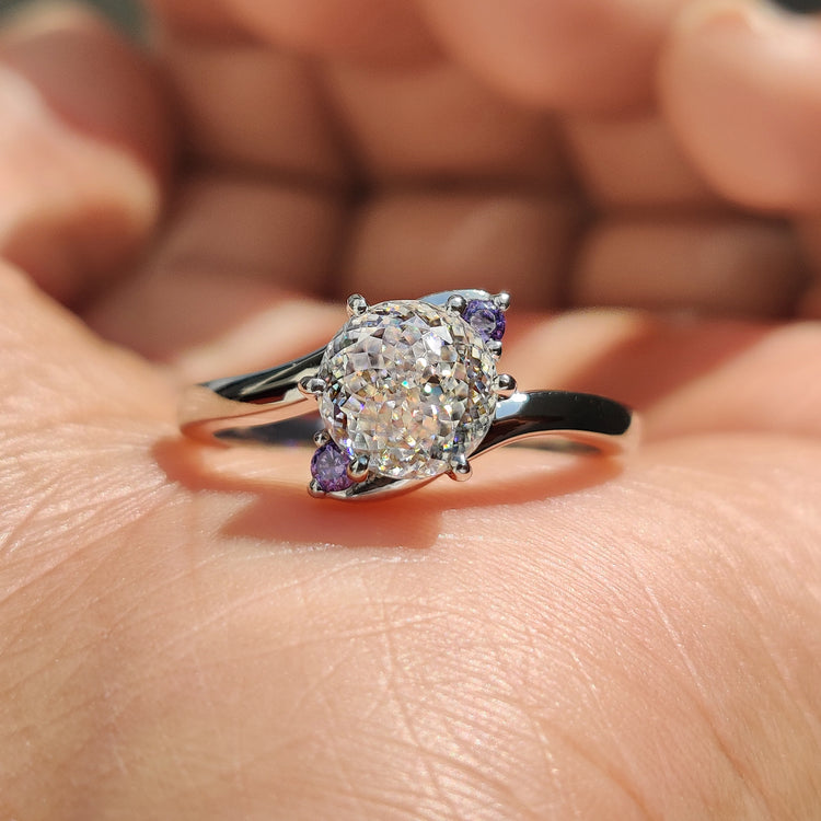 Three stone moissanite ring with Portuguese cut centre and rose cut side stones.